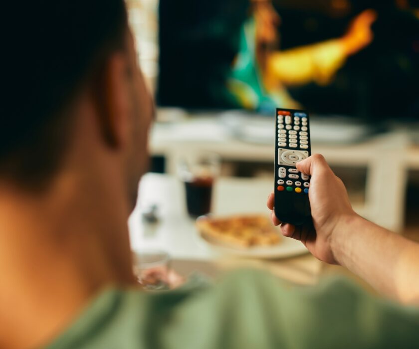 Close-up of man watching TV at home.